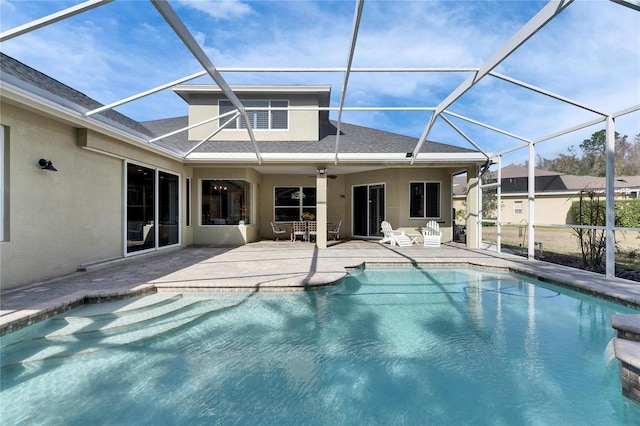 view of swimming pool featuring ceiling fan, a patio, and glass enclosure