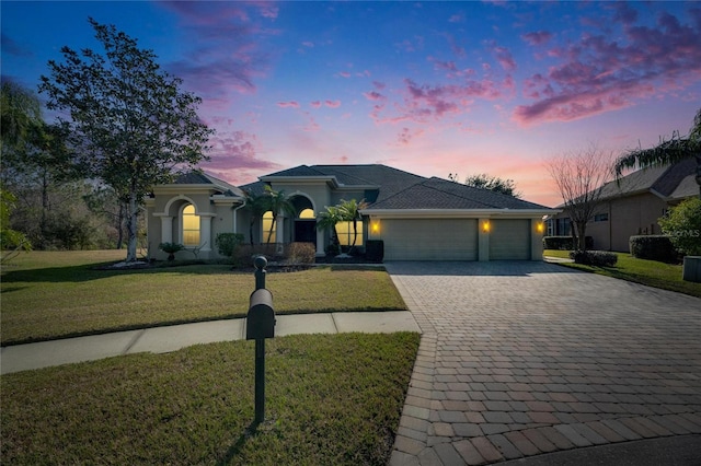 view of front of property with a garage and a lawn