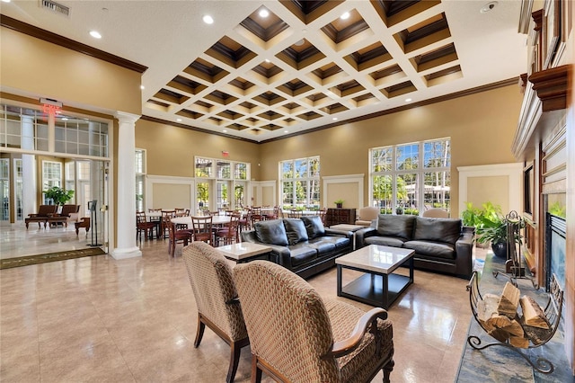 living room featuring ornamental molding, coffered ceiling, decorative columns, and a high ceiling