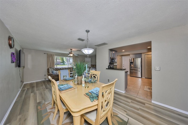 dining area featuring a textured ceiling and light wood-type flooring