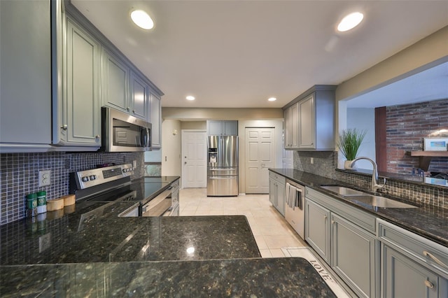 kitchen featuring light tile patterned flooring, appliances with stainless steel finishes, sink, dark stone countertops, and backsplash