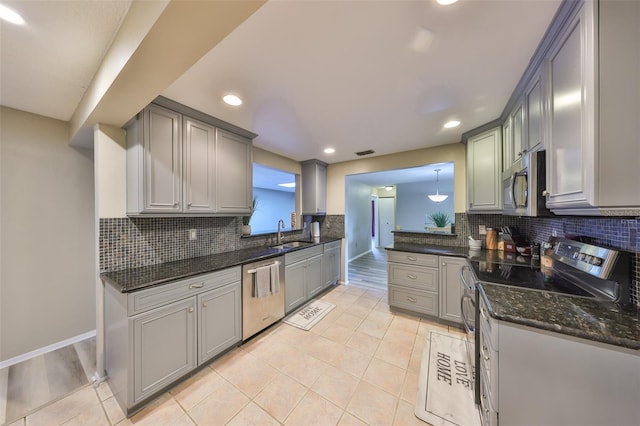 kitchen featuring light tile patterned flooring, sink, pendant lighting, stainless steel appliances, and decorative backsplash