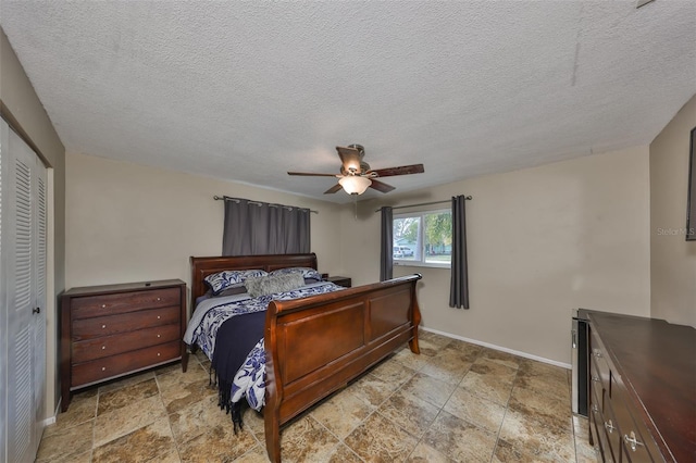 bedroom featuring a textured ceiling, ceiling fan, and a closet