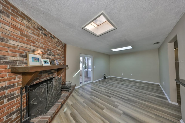 unfurnished living room featuring hardwood / wood-style flooring, a fireplace, and a textured ceiling