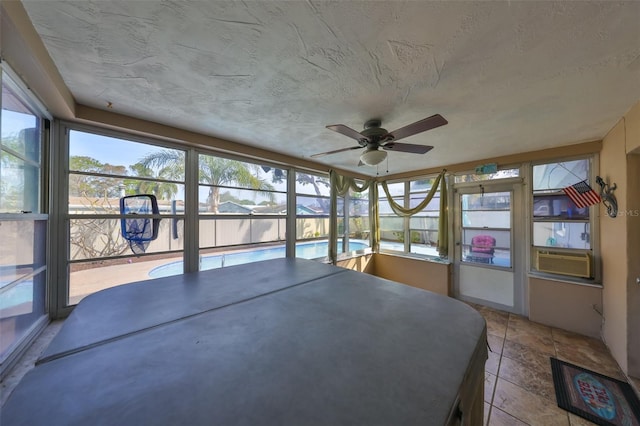 unfurnished sunroom with ceiling fan