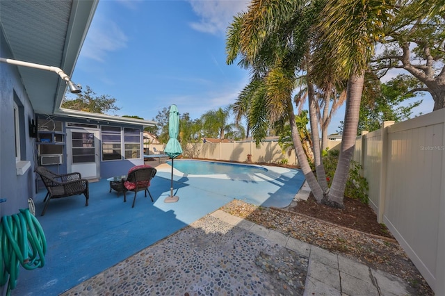 view of swimming pool featuring a patio area and a sunroom