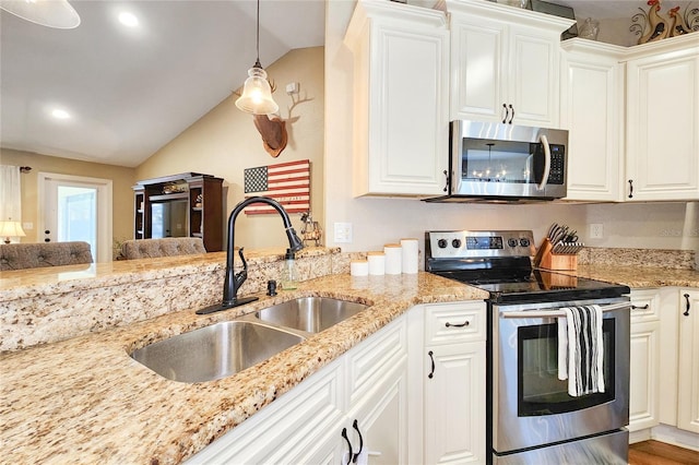 kitchen featuring vaulted ceiling, white cabinetry, appliances with stainless steel finishes, and sink