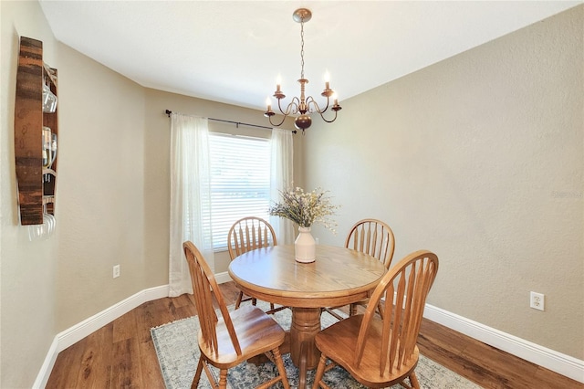 dining area with hardwood / wood-style flooring and a chandelier