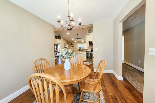 dining area featuring dark hardwood / wood-style flooring, sink, lofted ceiling, and a chandelier