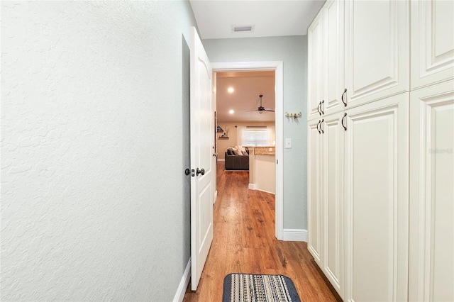 corridor with light hardwood / wood-style flooring