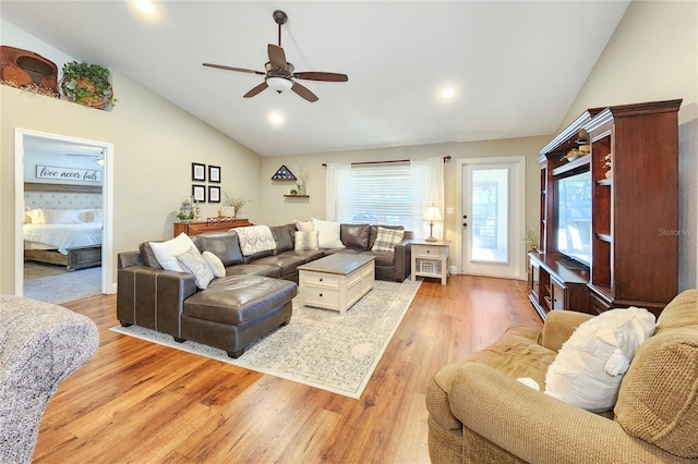 living room featuring lofted ceiling, light hardwood / wood-style flooring, and ceiling fan