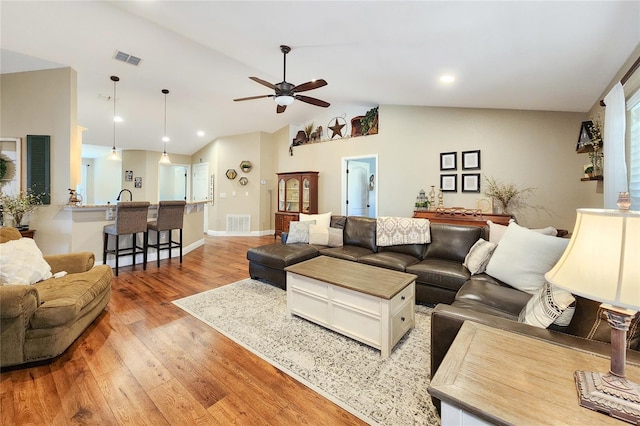 living room with lofted ceiling, light hardwood / wood-style flooring, and ceiling fan