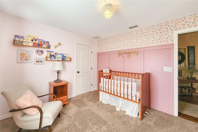 carpeted bedroom with a nursery area