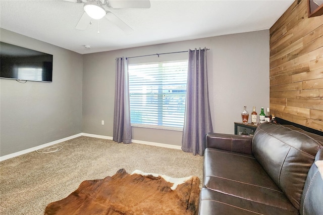 unfurnished bedroom with carpet floors, ceiling fan, and wood walls