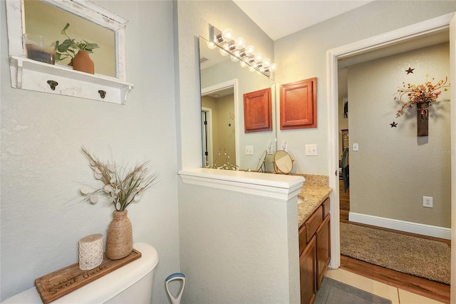 bathroom with hardwood / wood-style flooring and toilet