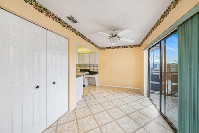 kitchen featuring tasteful backsplash, ceiling fan, and a textured ceiling