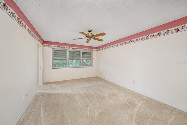 carpeted spare room featuring ceiling fan and a textured ceiling