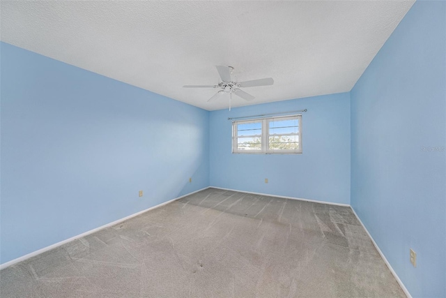 carpeted spare room featuring ceiling fan and a textured ceiling