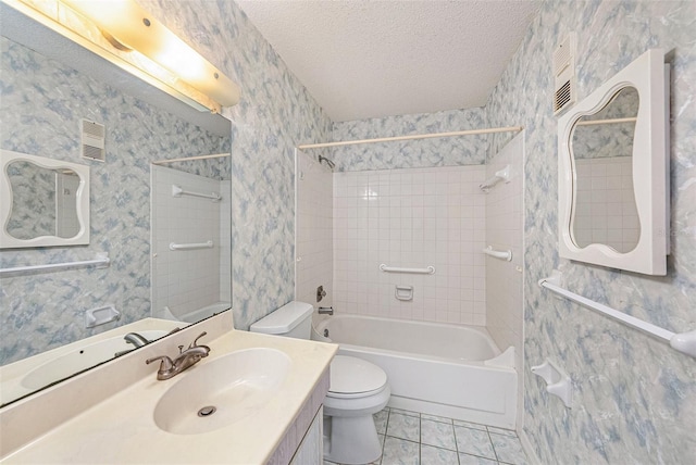 full bathroom with tiled shower / bath, tile patterned flooring, vanity, toilet, and a textured ceiling