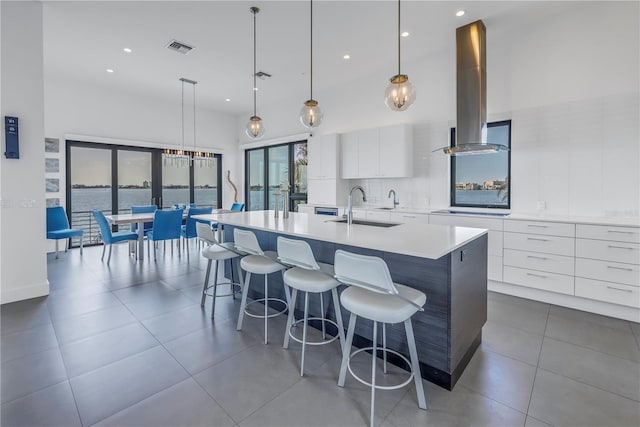 kitchen featuring sink, ventilation hood, pendant lighting, a large island, and white cabinets