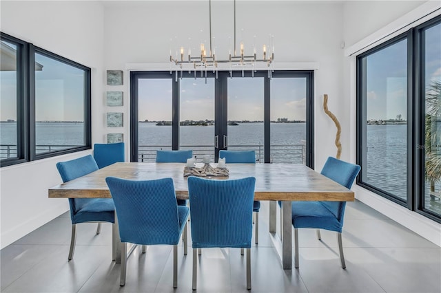 tiled dining room featuring plenty of natural light and a water view