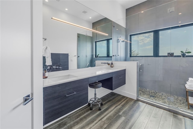 bathroom with vanity, hardwood / wood-style flooring, and a shower with door