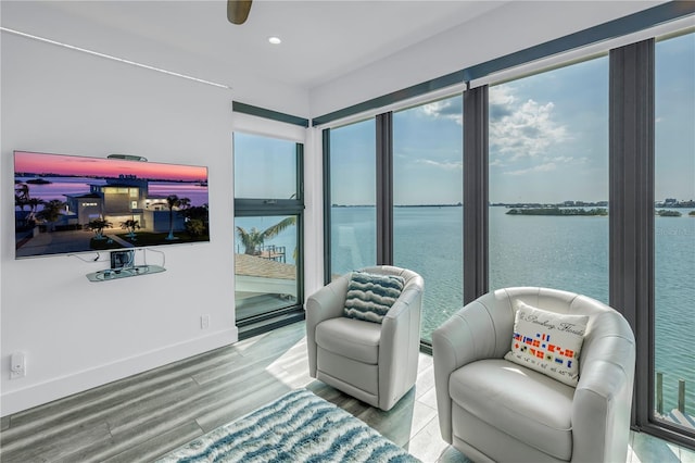 living area with a water view and hardwood / wood-style floors