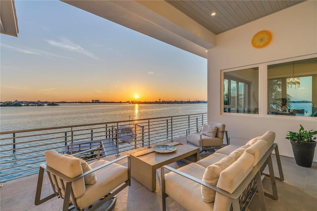 balcony at dusk with a water view and an outdoor hangout area