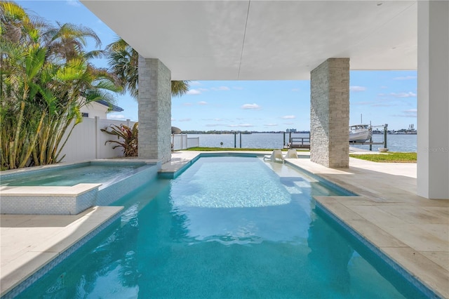 view of pool featuring an in ground hot tub and a water view