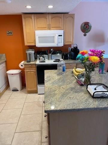 kitchen featuring light stone counters, white appliances, and light tile patterned flooring