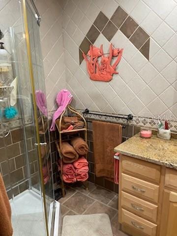 bathroom with vanity and a shower with door