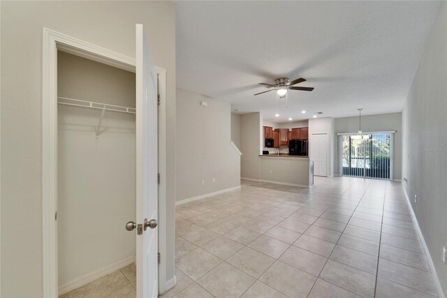 12973 Dream Catcher Way, Riverview, FL 33579 - interior space featuring ceiling fan with notable chandelier, black refrigerator, light tile patterned floors, and a textured ceiling