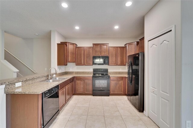 12973 Dream Catcher Way, Riverview, FL 33579 - kitchen featuring sink, light tile patterned floors, light stone counters, black appliances, and kitchen peninsula