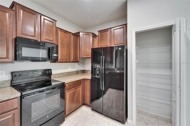 12973 Dream Catcher Way, Riverview, FL 33579 - kitchen featuring light tile patterned floors, a textured ceiling, and black appliances