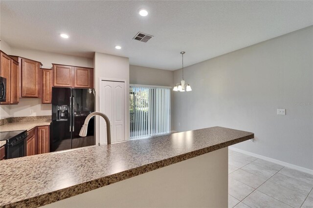 12973 Dream Catcher Way, Riverview, FL 33579 - kitchen with light tile patterned floors, an inviting chandelier, black appliances, a textured ceiling, and decorative light fixtures