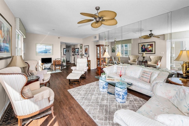 living room with ceiling fan, dark hardwood / wood-style floors, and a textured ceiling