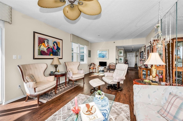 living room with dark hardwood / wood-style floors, a textured ceiling, and ceiling fan