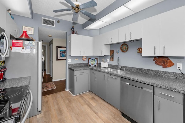 kitchen with sink, gray cabinets, white cabinetry, stainless steel appliances, and light wood-type flooring