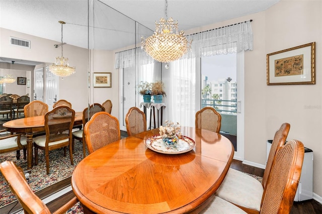 dining space featuring dark hardwood / wood-style floors and a chandelier