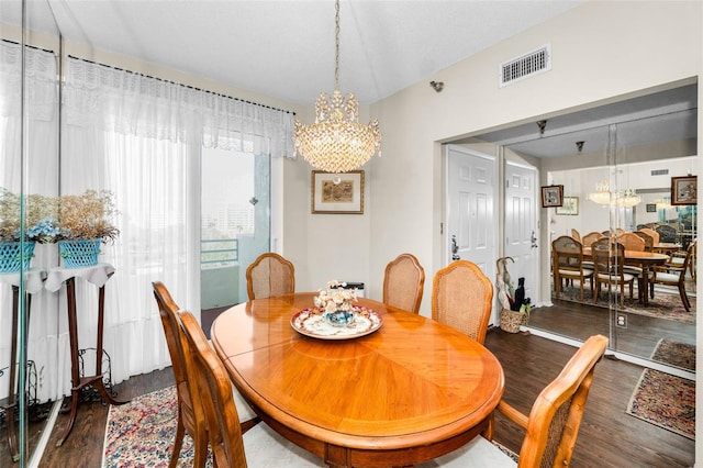 dining room featuring dark hardwood / wood-style floors and an inviting chandelier