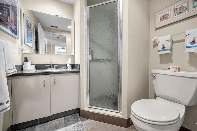 bathroom with tile patterned floors, vanity, toilet, and a shower with shower door