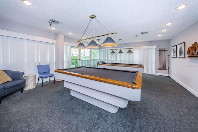 game room with pool table, a textured ceiling, and dark colored carpet