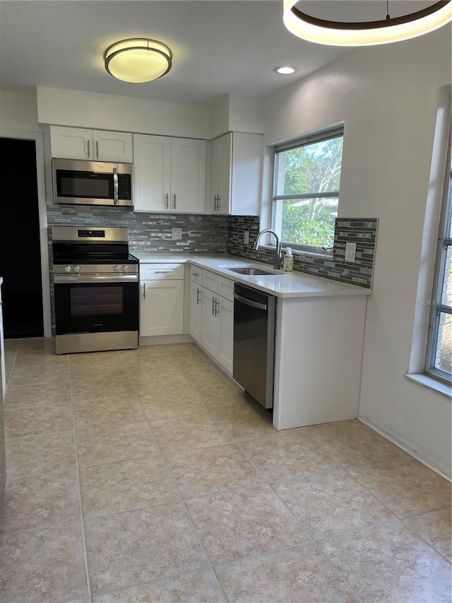 kitchen featuring white cabinetry, appliances with stainless steel finishes, sink, and decorative backsplash