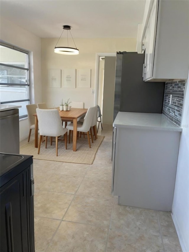 kitchen featuring decorative light fixtures, fridge, stainless steel refrigerator, and light tile patterned flooring