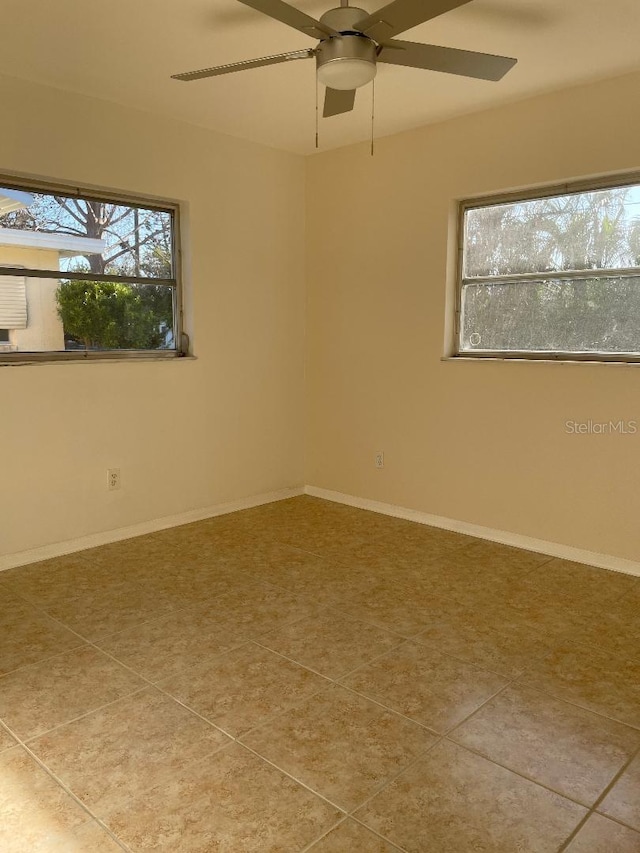 tiled spare room with a wealth of natural light and ceiling fan