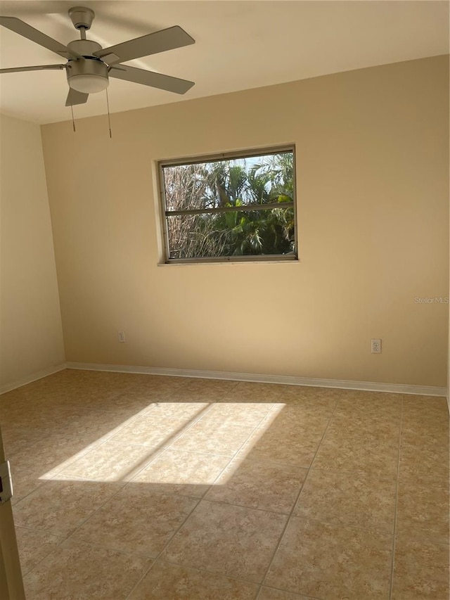 tiled spare room with ceiling fan