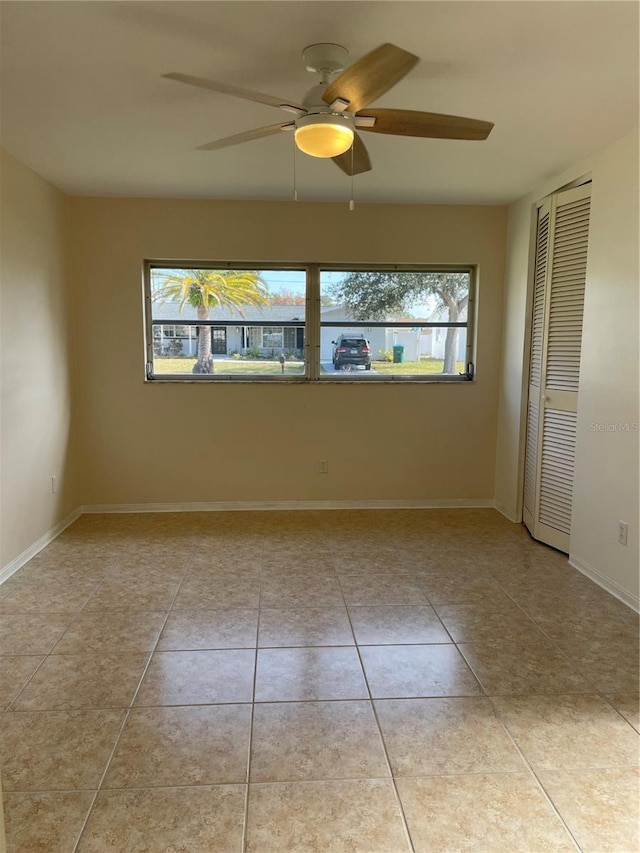 tiled empty room with a wealth of natural light and ceiling fan