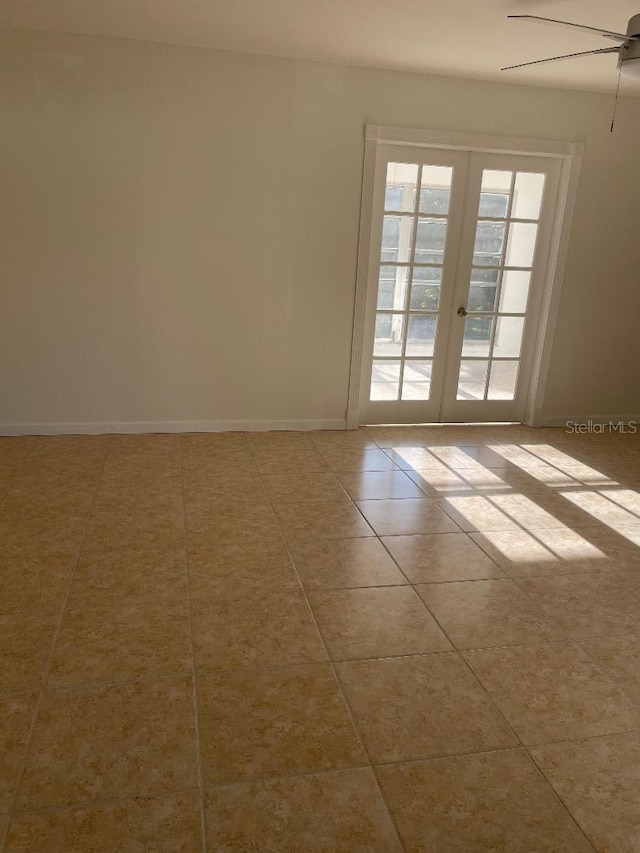 spare room featuring french doors, ceiling fan, and light tile patterned floors