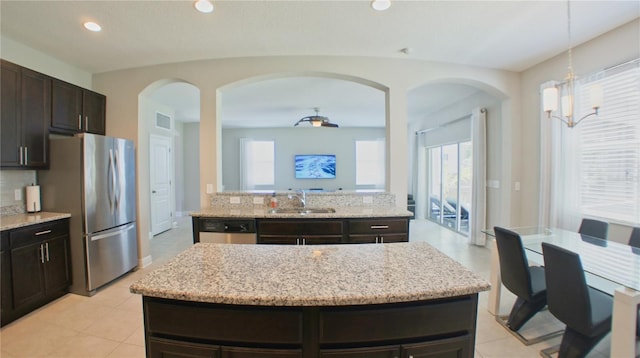 kitchen featuring appliances with stainless steel finishes, a center island, sink, and dark brown cabinets