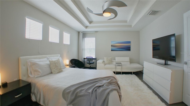 bedroom featuring ceiling fan and a tray ceiling